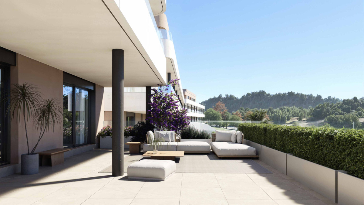 Eagle Hills – Estepona - ground-floor terrace with white outdoor lounge furniture, bougainvillea, and wooded hillside views