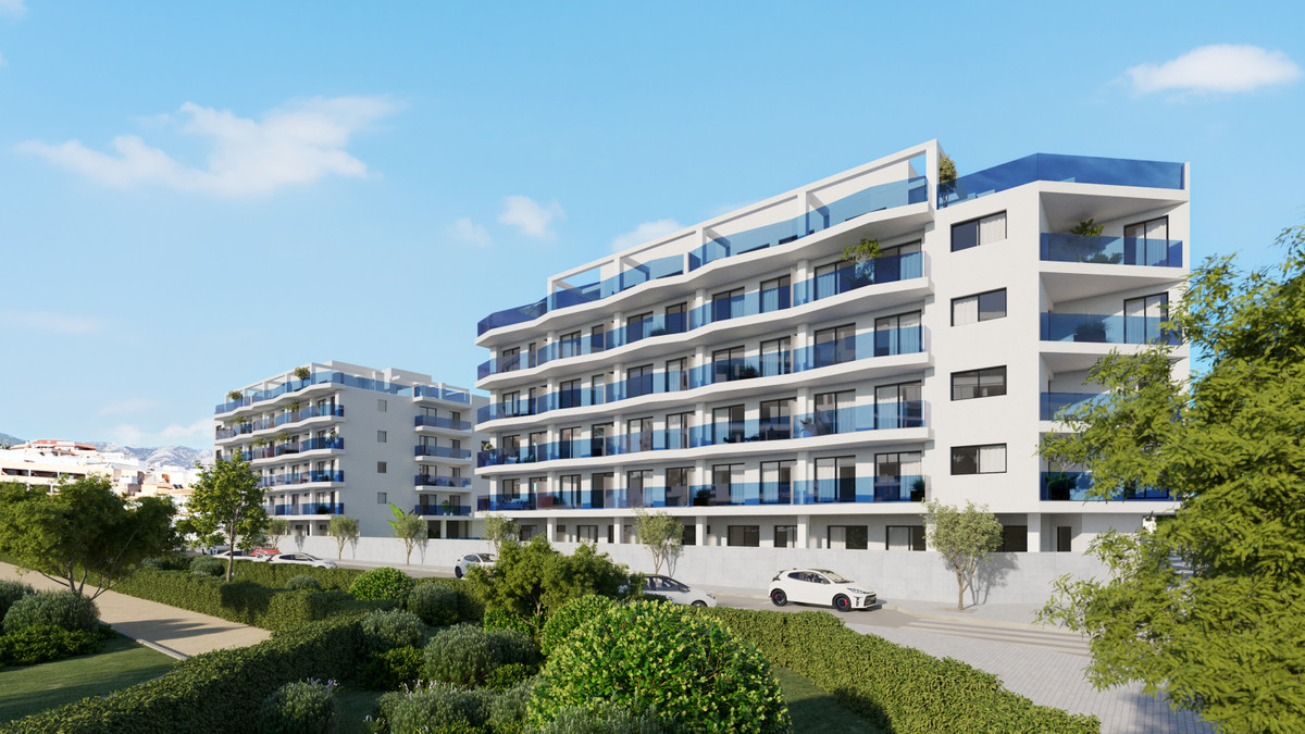 Laguna One – Las Lagunas - modern white residential facade with blue-glass balconies surrounded by lush landscaped gardens