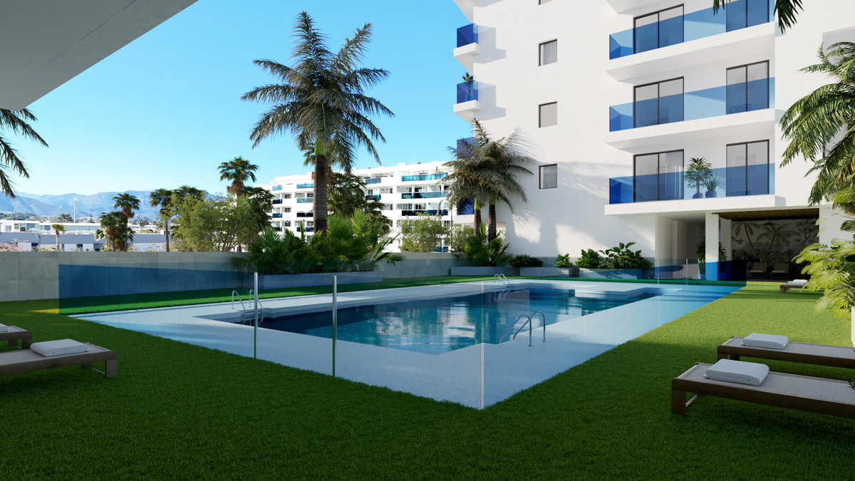 Laguna One – Las Lagunas - outdoor swimming pool and landscaped garden with palm trees and white apartment building