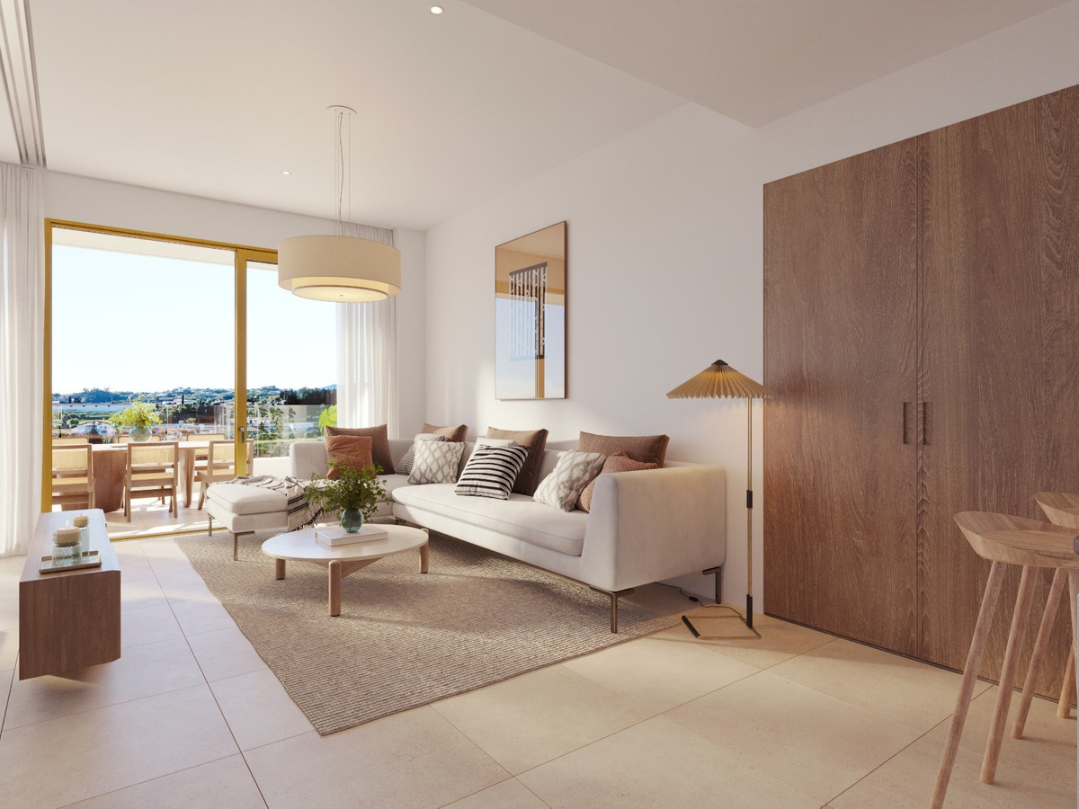 LUMINAL HOMES – Fuengirola - bright open-plan living room with white sofa, wooden wardrobe, and panoramic terrace views