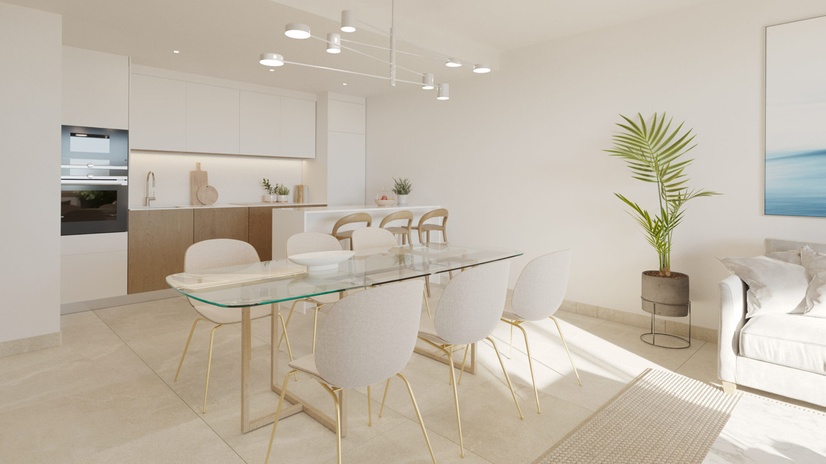 Adagio – Cancelada - open-plan dining and kitchen area with glass table, gold chairs, and white cabinetry