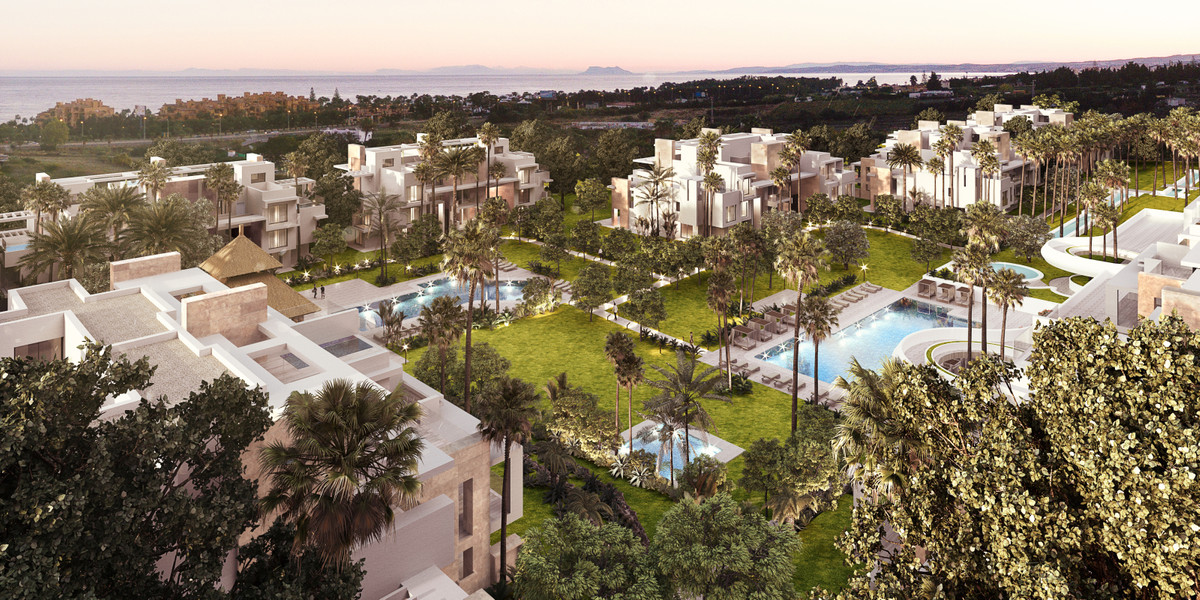 Ayana Estepona – New Golden Mile - aerial view of luxury white villas with palm-lined gardens and illuminated pools at dusk, sea in background