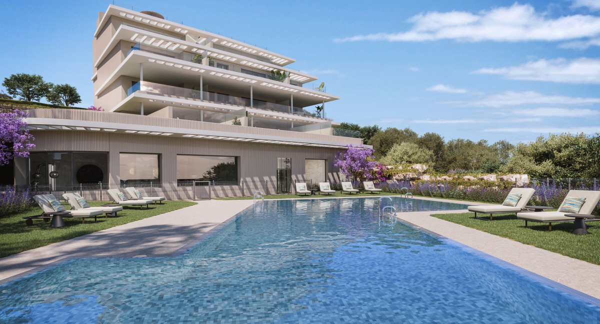 Capri – Fase 3 – Estepona - luxury outdoor pool and sun loungers with modern multi-storey residential building and lush garden