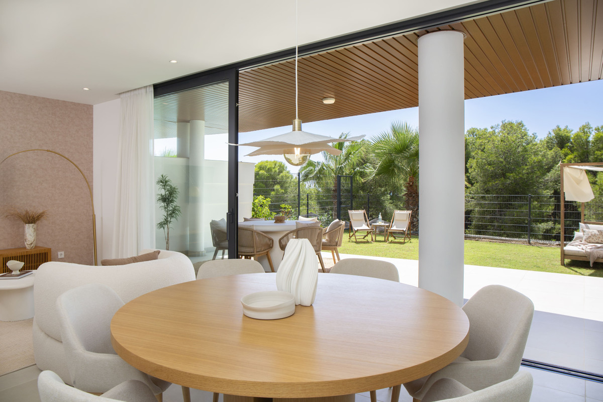 Higueron West - Fuengirola - open-plan dining area with round oak table flowing to covered terrace and lush garden beyond