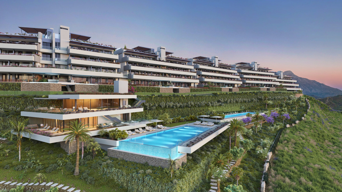 Tiara – Benahavís - luxury hillside residential development with large infinity pool, terraced apartments and lush landscaped gardens at dusk