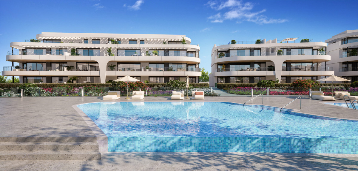 Naya Residences – Atalaya - luxury apartment complex exterior with communal pool, sun loungers and landscaped gardens