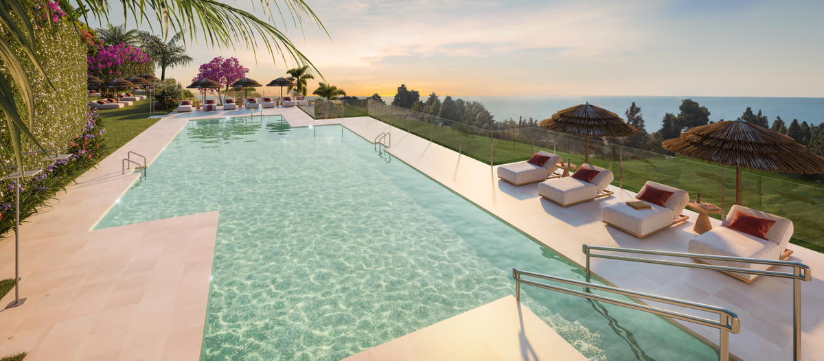 Soleia Living – El Chaparral - infinity pool with sea views, sun loungers and tropical landscaping at sunset