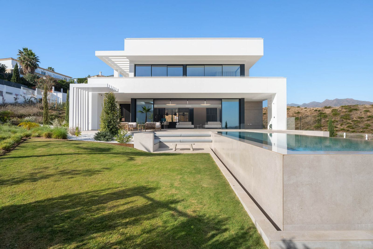 Tree Villas – La Cala Golf - modern white villa exterior with infinity pool, lush lawn and mountain backdrop