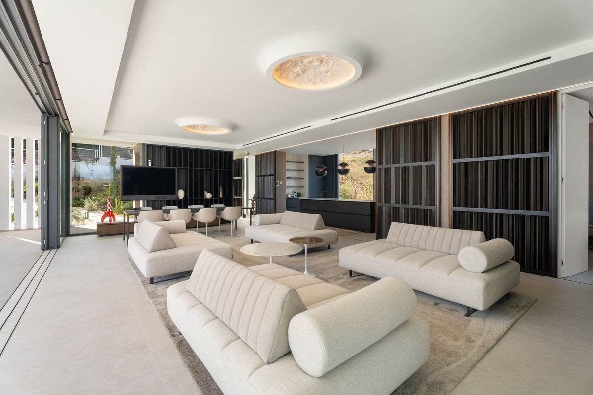 Tree Villas – La Cala Golf - spacious open-plan living room with cream sofas, circular ceiling lights and dark feature walls