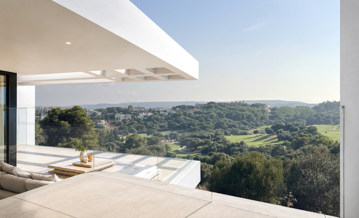 VILLA EVANIA de La Reserva – San Roque - covered terrace with glass balustrade and panoramic golf course and woodland views