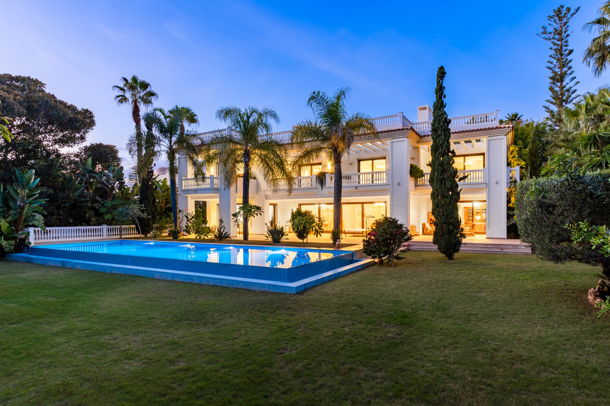 Villa Murcia – Estepona - luxury white villa exterior with illuminated pool and tropical gardens at dusk