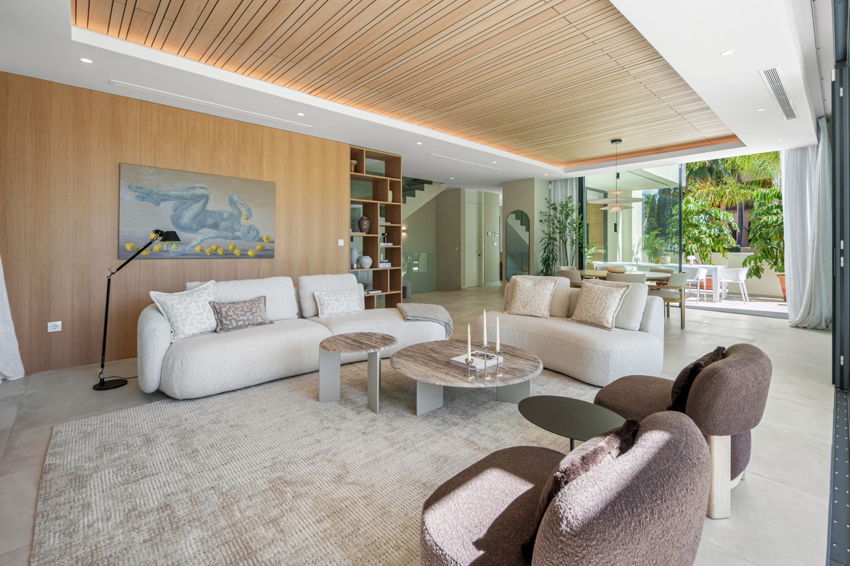Belfry 1 – Estepona - open-plan living room with cream sofas, wood-panelled walls, and garden views