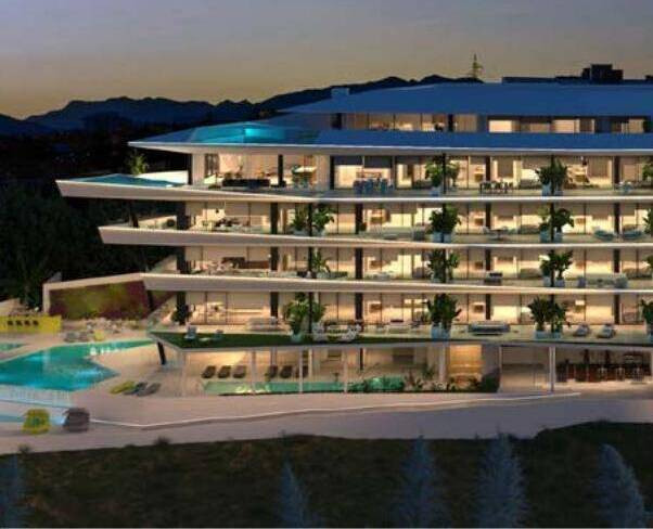 Carat Fase II – Fuengirola - illuminated modern luxury residential exterior with pool and terraces at dusk