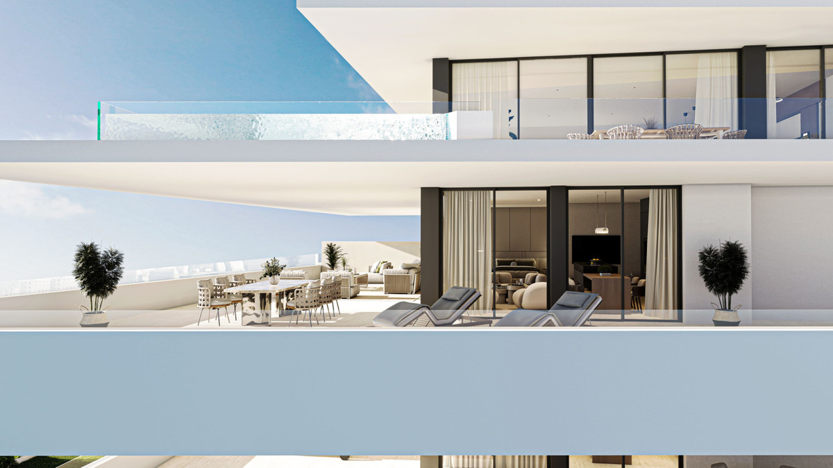 Carat Fase II – Fuengirola - luxury terrace with sun loungers, outdoor dining area and open-plan living room behind floor-to-ceiling glass doors