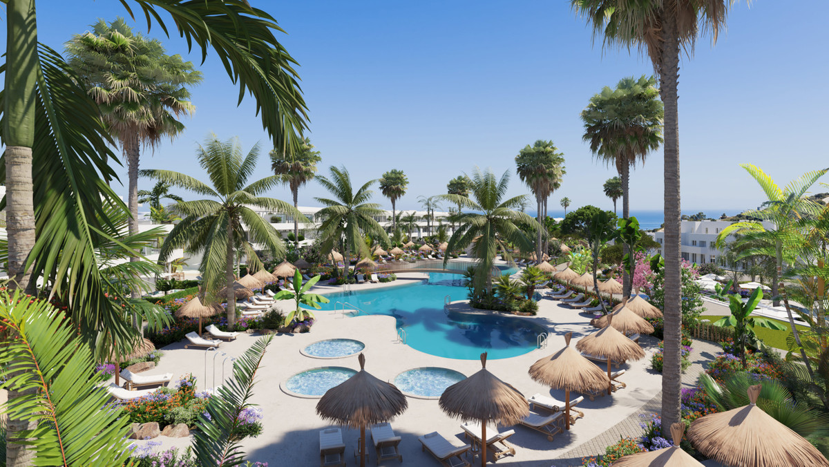 Serenity Frontline Golf Homes and Beach Club – PHASE III – La Alcaidesa - luxury outdoor pool area with palm trees, thatched umbrellas and sun loungers