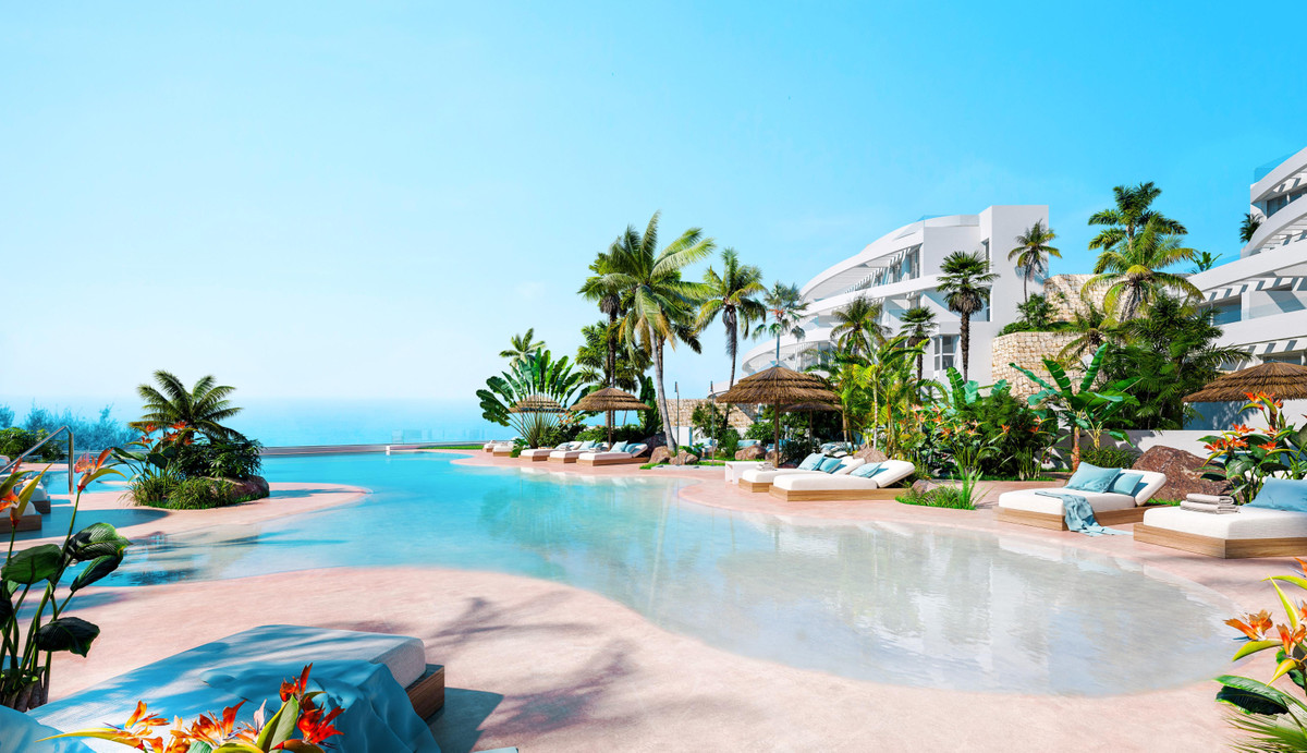 Royal Palms Mijas – FASE IV-1 – La Cala de Mijas - lagoon-style infinity pool surrounded by tropical palms, sun loungers and white resort apartments with sea views