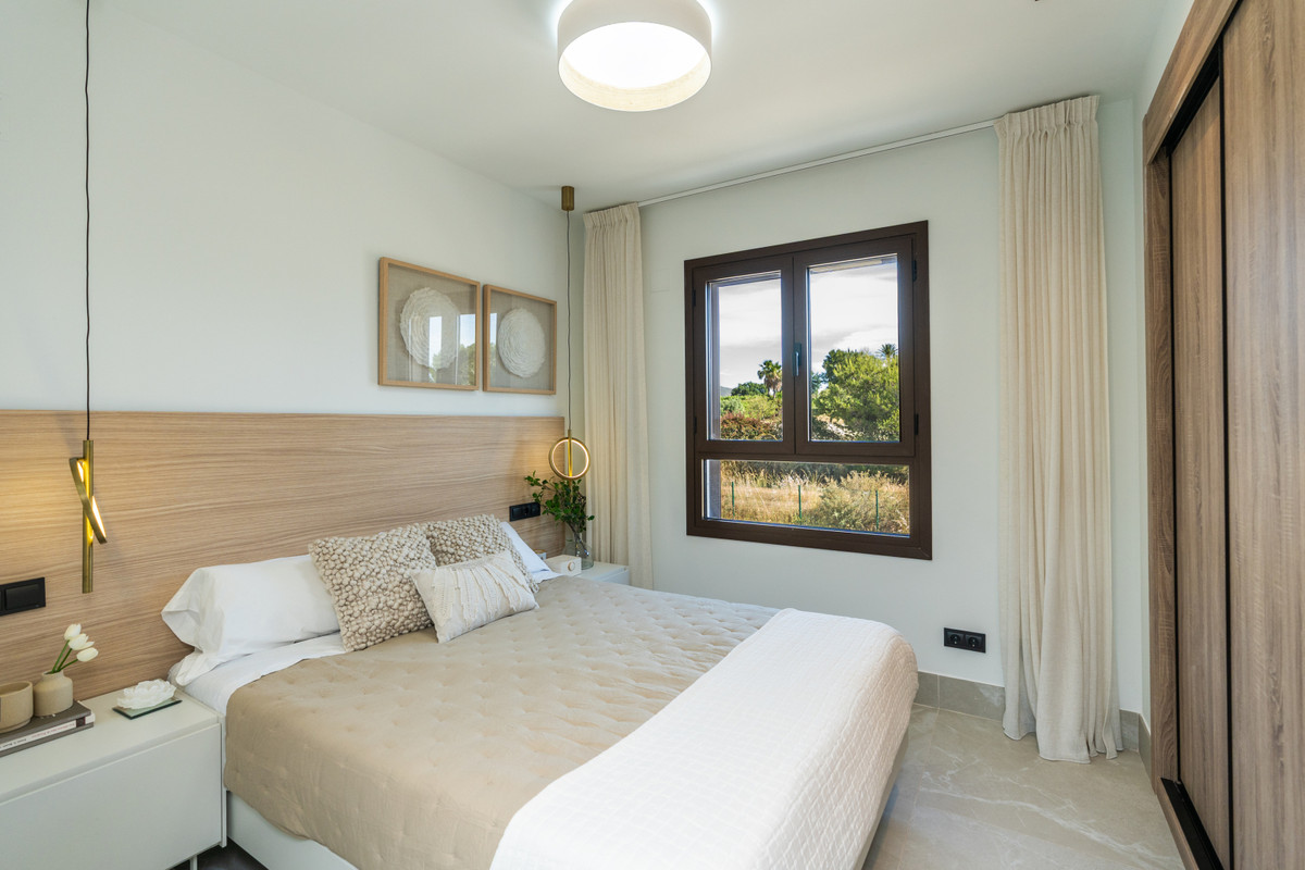 The Meadows – FASE 1 – La Cala Golf - elegant bedroom with wood headboard, pendant lights, and garden views