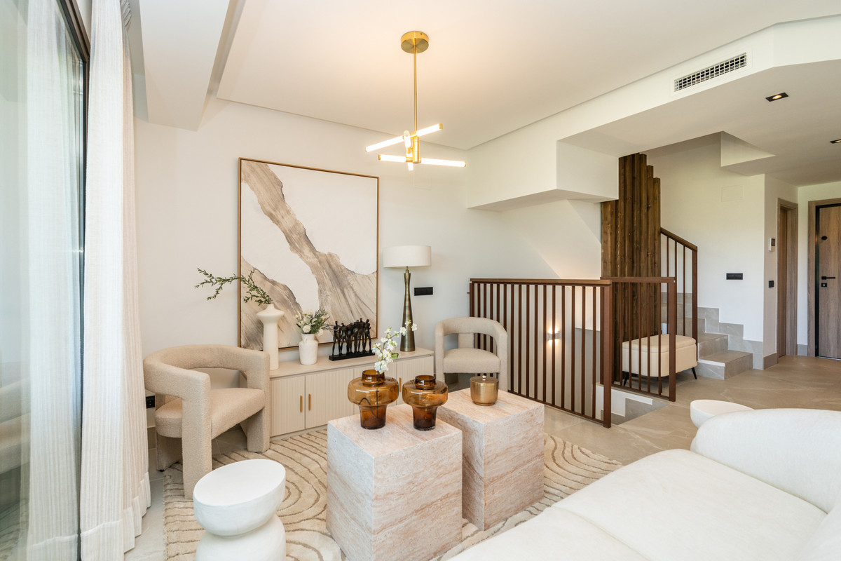The Meadows – FASE 1 – La Cala Golf - elegant upper-level living area with cream armchairs, stone coffee tables, and warm gold pendant light